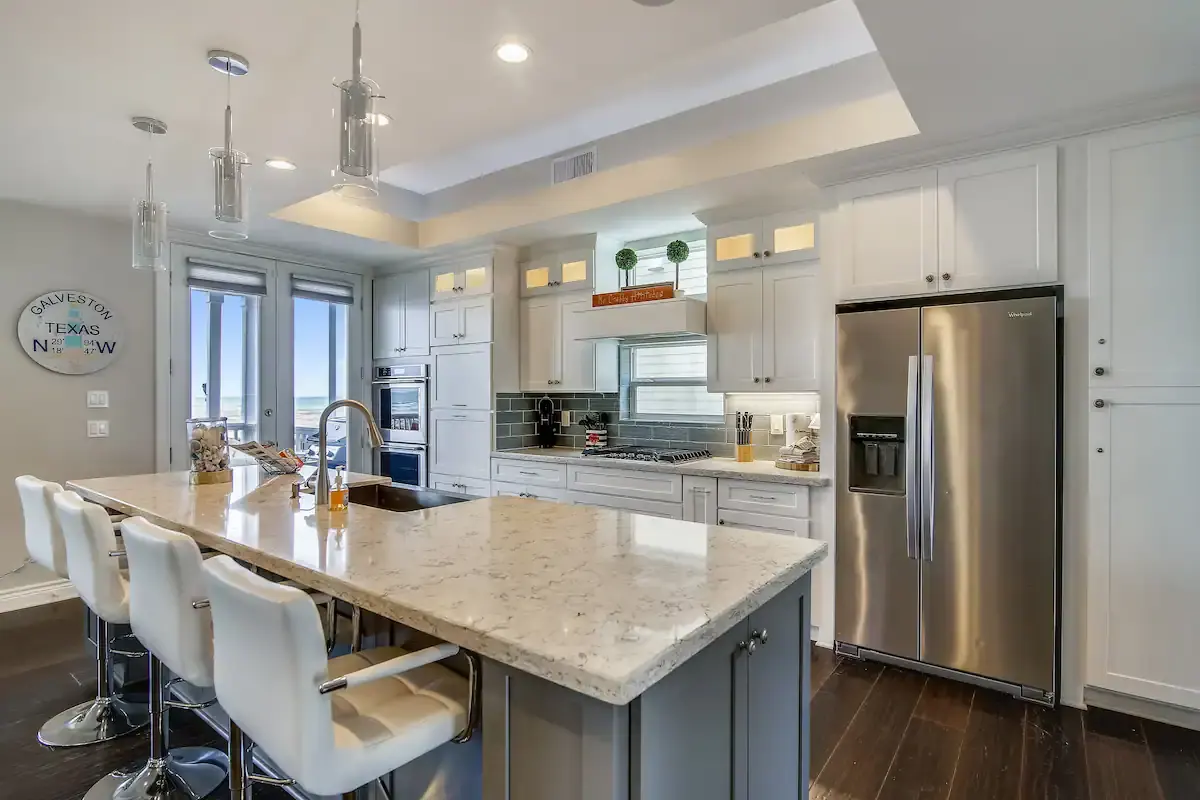 Kitchen island with bar seating, stainless appliances, and beach views at Sunrise on the Beach