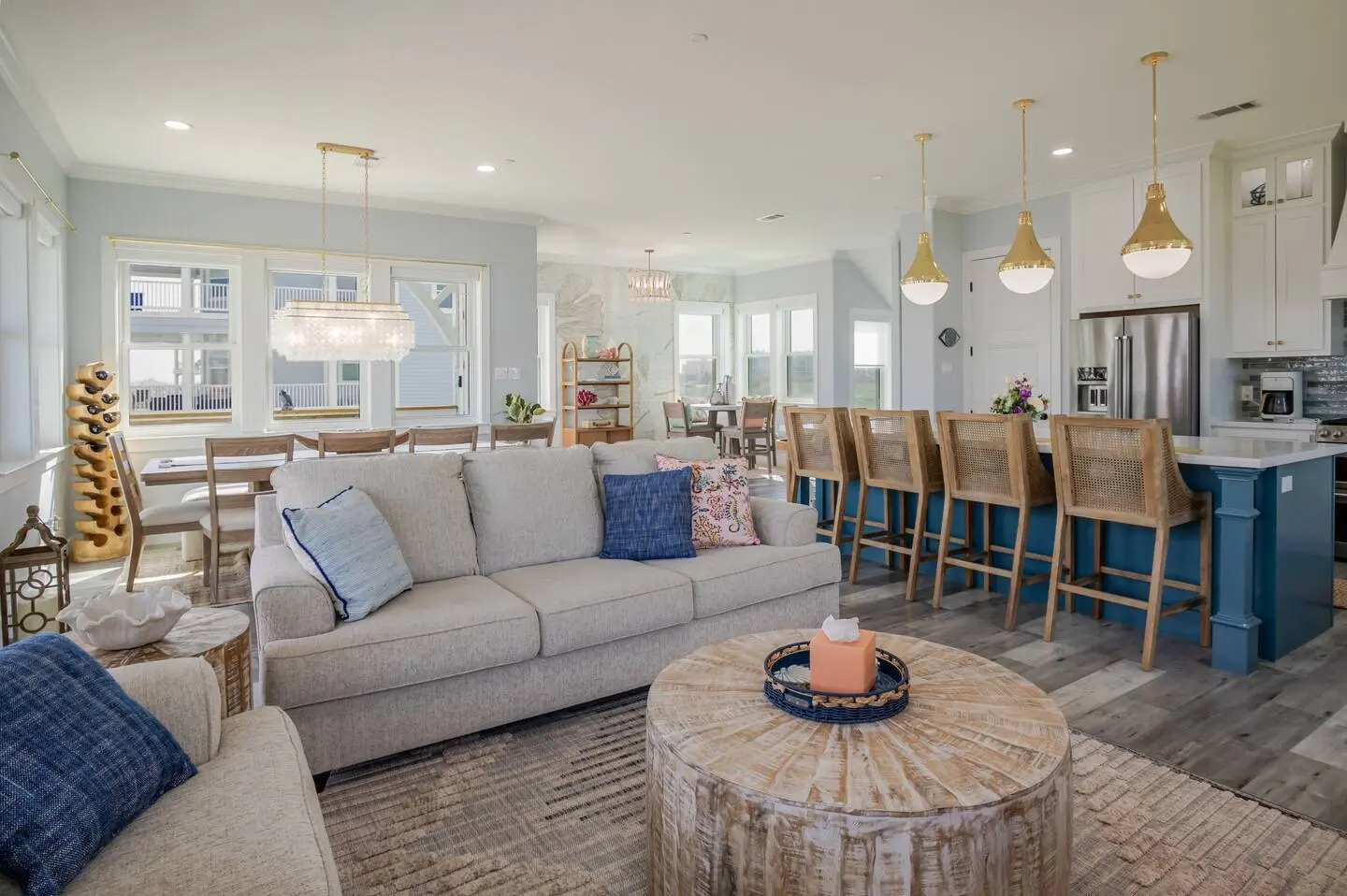 Open-plan great room with dining area and blue kitchen island at Alma de Mar