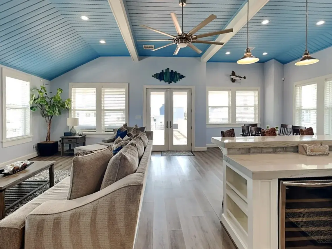 Sunlit seating area beneath the blue shiplap ceiling at Tiki Retreat