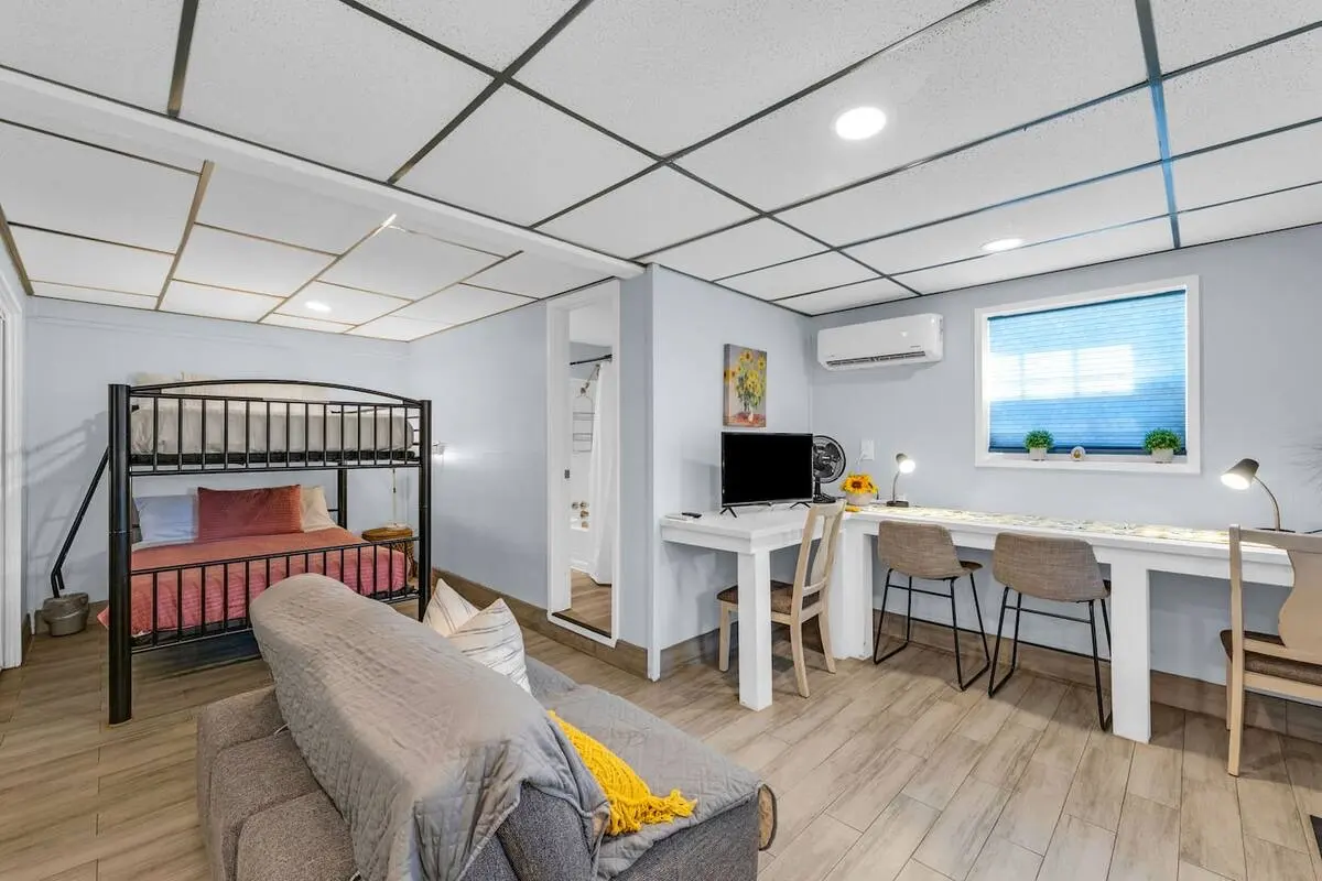 Downstairs suite with full-size bunk bed, sofa, and desk space at Oasis by the Bay