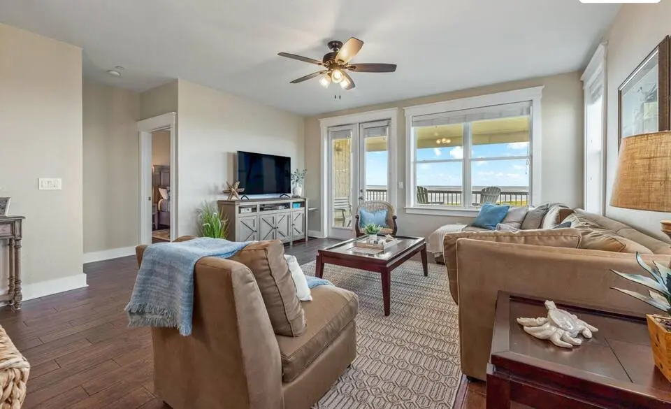 Living area with TV and doors to the balcony at Top-Floor Condo at Pointe West