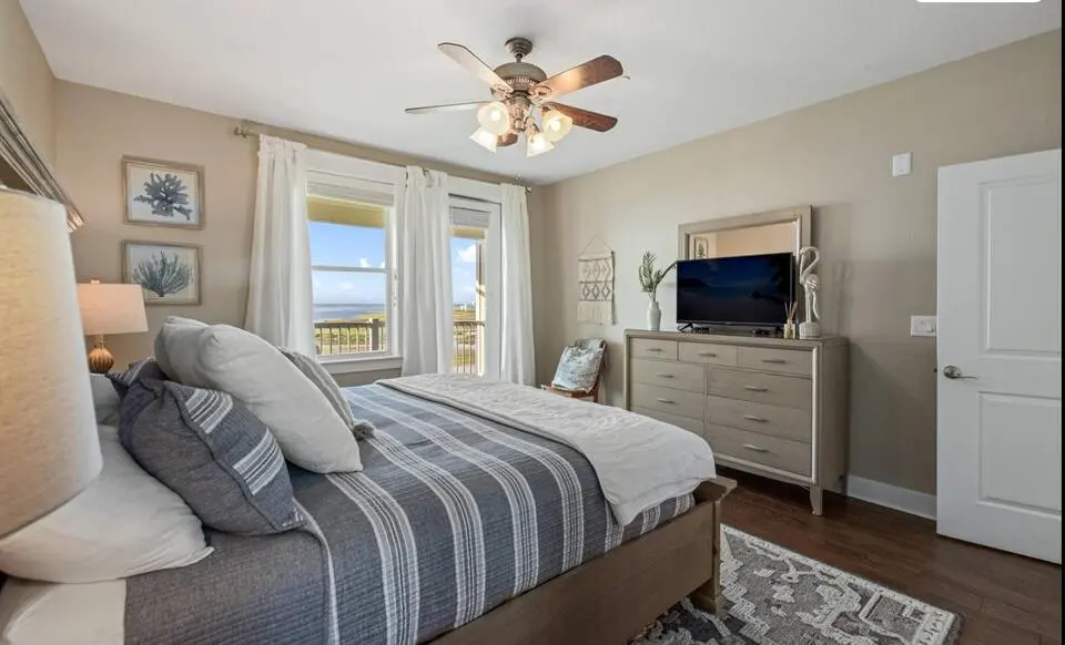 Bedroom with striped bedding and dresser at Top-Floor Condo at Pointe West