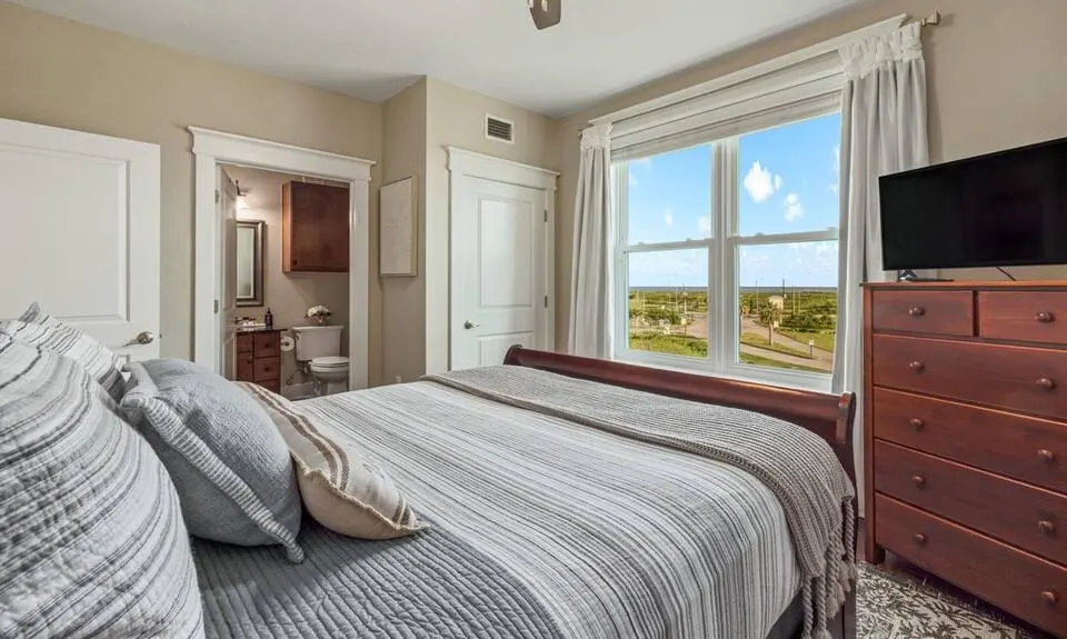 Bedroom with TV and private bathroom door at Top-Floor Condo at Pointe West