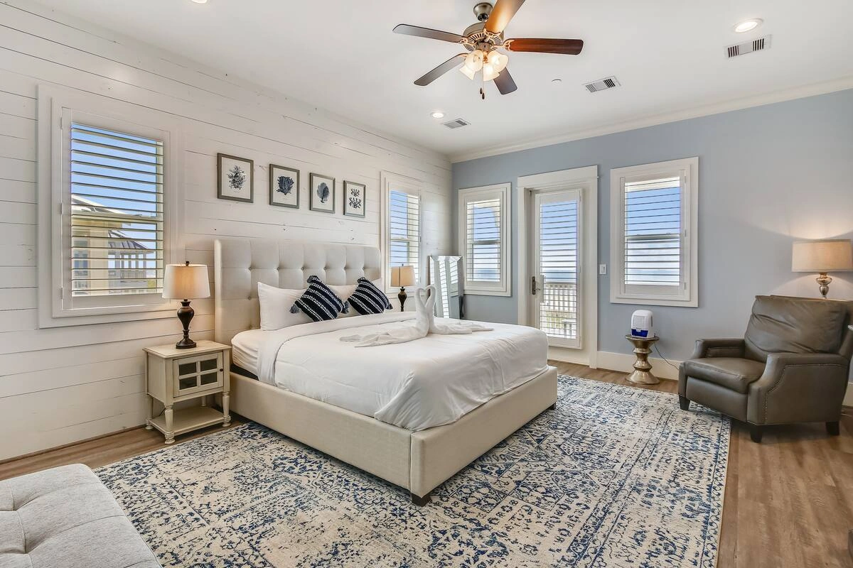 Primary bedroom with king bed, shiplap accent wall, and balcony access at Dorado Grande